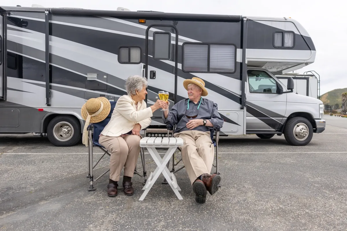 Elderly couple toasting by RV